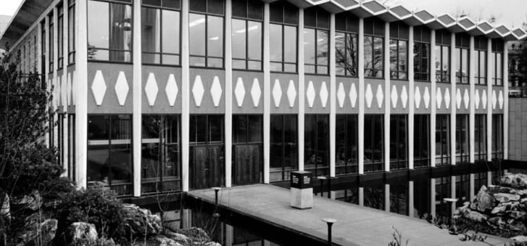 A historical black and white photo of the BC Archives building.
